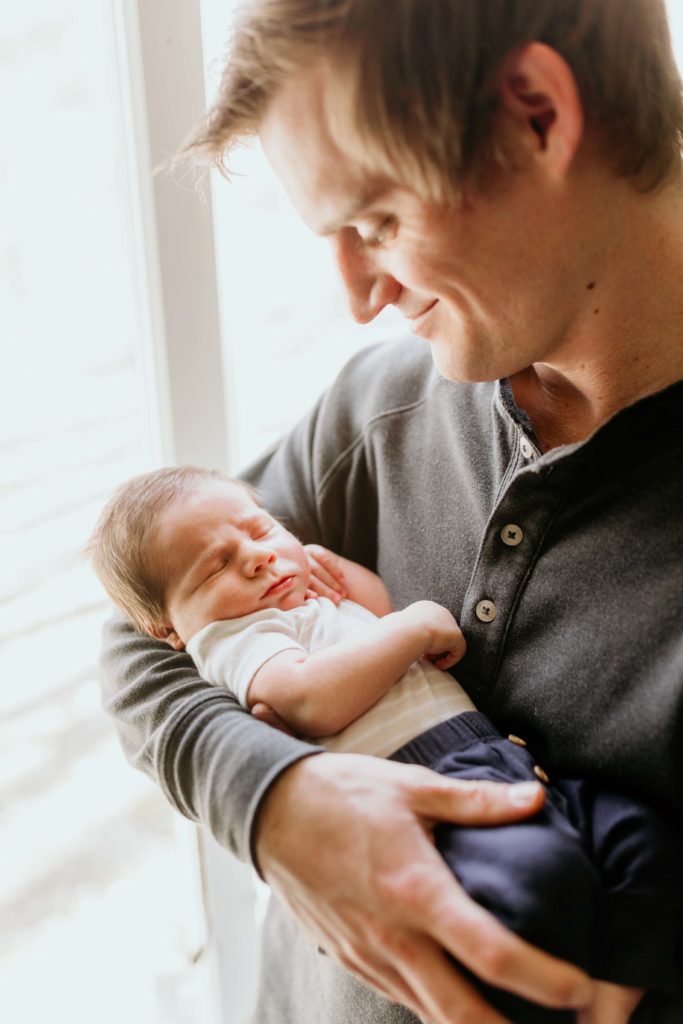 Dad holding baby In Home Newborn Photography